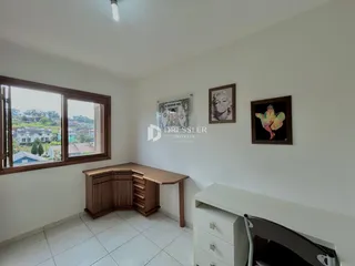 Uma sala de estar com grande janela que oferece vista para a paisagem externa.