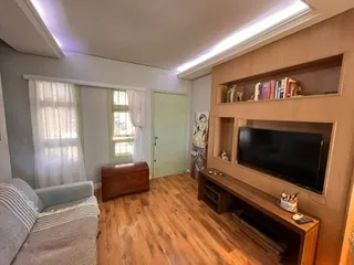 Sala de estar com sofá e piso de madeira clara.