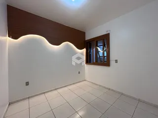 Uma sala de estar moderna com piso de cerâmica clara e detalhes em madeira.
