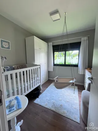 Quarto com cama de madeira e armário branco em ambiente interno.