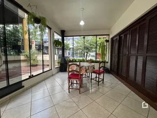 Sala de jantar com vista para o jardim através de grandes janelas.