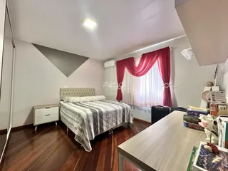 Quarto com cama e janela com cortinas vermelhas em Lajeado, Brasil.