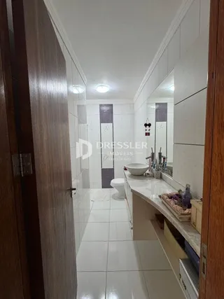 Corredor interno de uma residência com piso e paredes brancas.