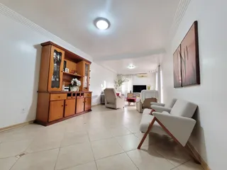 Sala de estar com decoração de madeira e mobiliário claro.