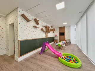 Foto de uma área comum com piso de madeira e brinquedos coloridos.