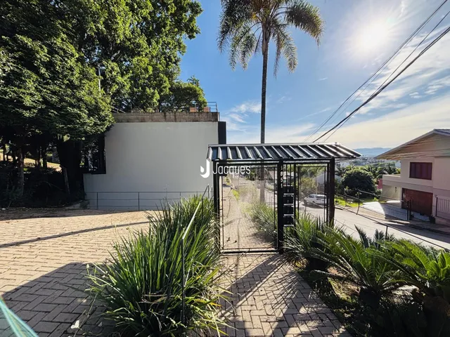 Vista externa de uma propriedade em Lajeado, Brasil, com jardim e portão de metal.