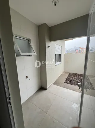 Vista de um corredor interno com porta e abertura para uma área externa.