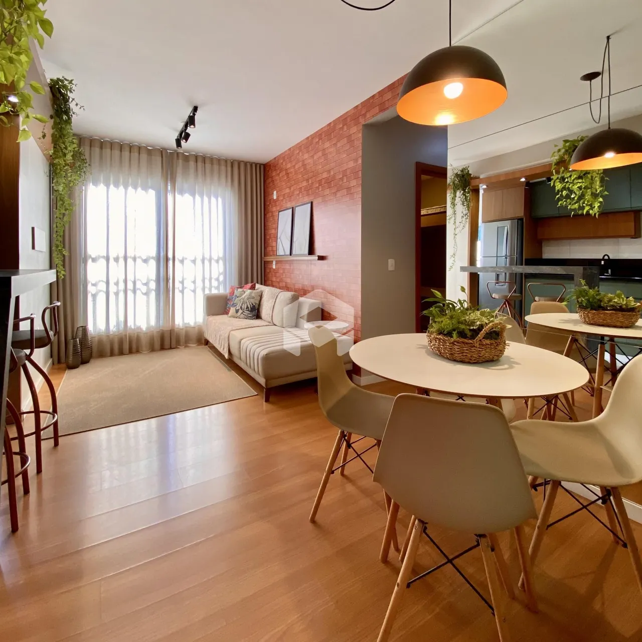 Sala de estar com piso de madeira e área de jantar em um imóvel no Brasil.