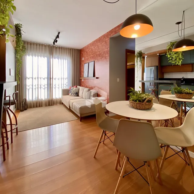 Sala de estar com piso de madeira e área de jantar em um imóvel no Brasil.