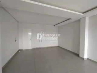 Interior de um ambiente com paredes brancas e piso de cerâmica.