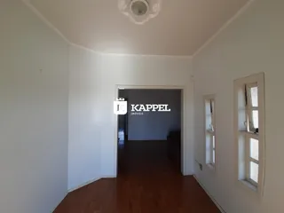 Hall de entrada com piso de madeira e paredes brancas.