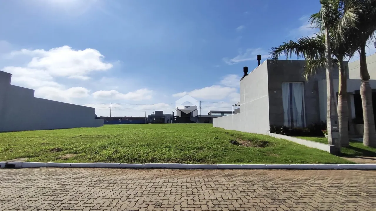 A fachada da propriedade mostra um gramado extenso e uma parede branca.