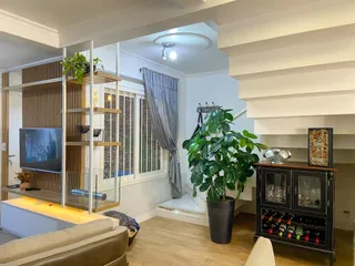 Sala de estar com piso de madeira e estante de TV.