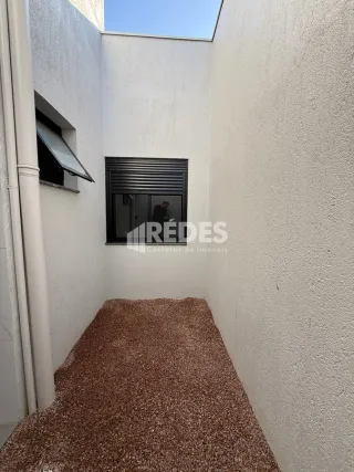 Corredor interno de uma residência com paredes brancas.