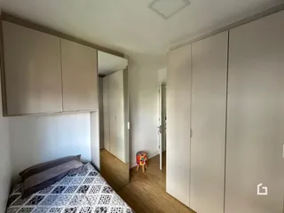 Quarto com armários embutidos e piso de madeira clara.