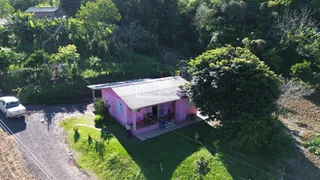 Foto da fachada de uma residência em Lajeado, Brasil, cercada por vegetação densa.