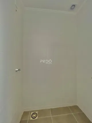 Interior de um banheiro com revestimento cerâmico nas paredes e piso.