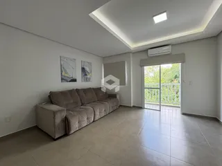 Sala de estar com sofá e piso de cerâmica em um imóvel no Brasil.