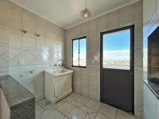 Foto de um banheiro com revestimento cerâmico e janela.