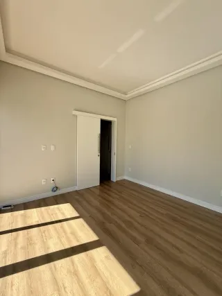 Ambiente interno com piso de madeira e teto de gesso claro.