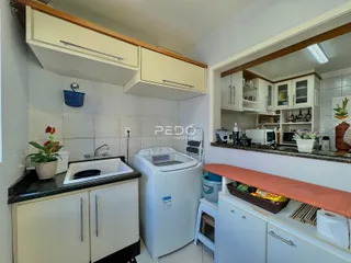 Foto de uma cozinha interna com armários brancos e bancada.