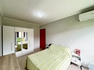Quarto com cama e armários brancos em um imóvel no Brasil.