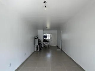 Corredor interno de uma residência com paredes brancas e piso de cerâmica.
