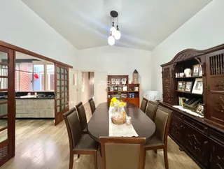 Uma sala de jantar com móveis de madeira escura e piso de madeira.