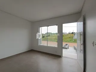 Ambiente interno de uma sala com piso de cerâmica e vista para o exterior.