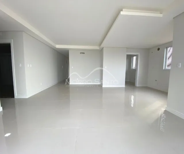 Ambiente interno amplo com piso claro e paredes brancas.