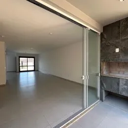 Foto de um corredor interno com piso claro e divisória de vidro.