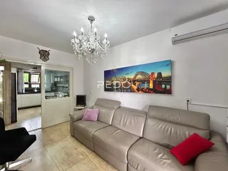 Sala de estar com sofá e televisão em um imóvel no Brasil.