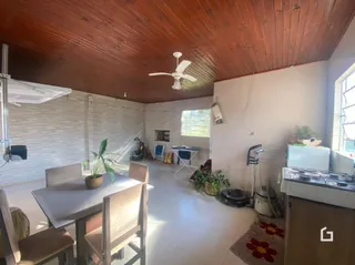 Imagem de uma sala de jantar com piso de cerâmica e teto de madeira.