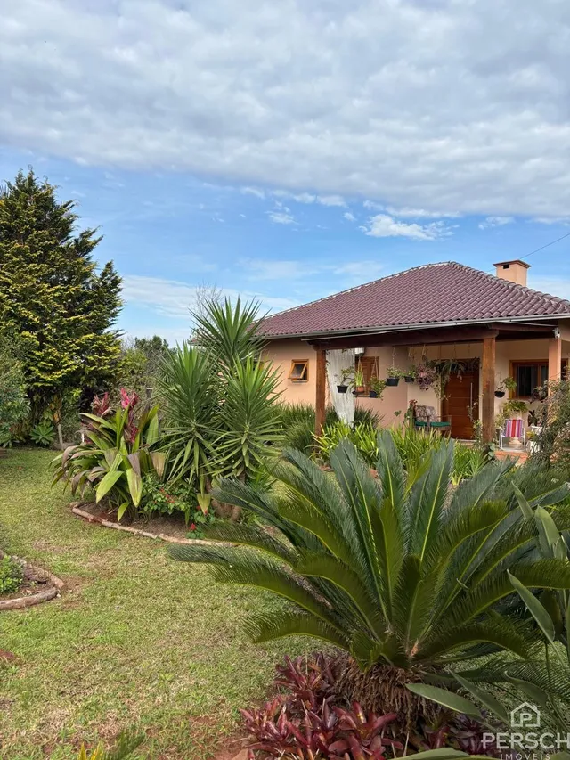 Foto da fachada de uma casa em Lajeado, Brasil, com jardim exuberante.
