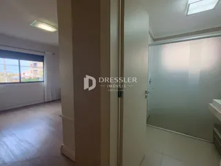 Hall de entrada interno com piso de madeira e porta de vidro.