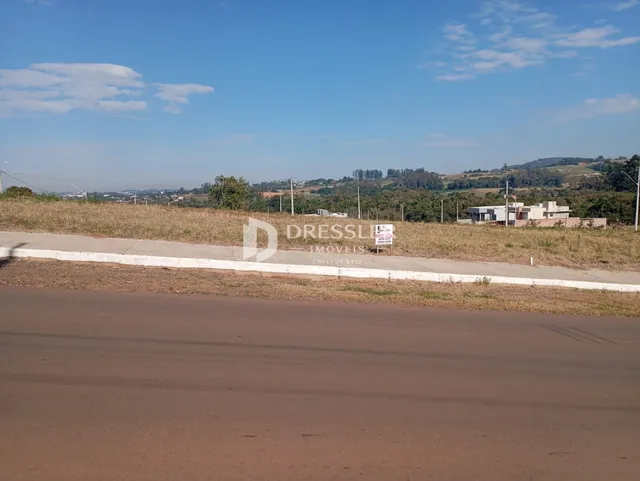 Vista panorâmica de uma paisagem rural com colinas ao fundo.