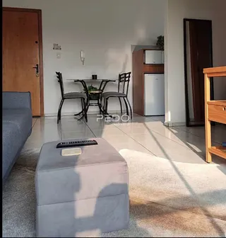 Sala de estar e jantar com piso de cerâmica e móveis de madeira.