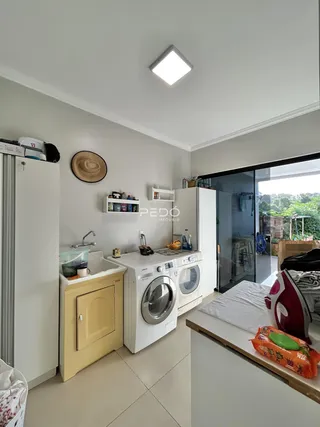 Foto de uma cozinha moderna com máquinas de lavar e armários brancos.