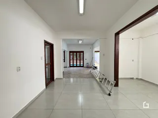Hall de entrada com piso claro e paredes brancas.