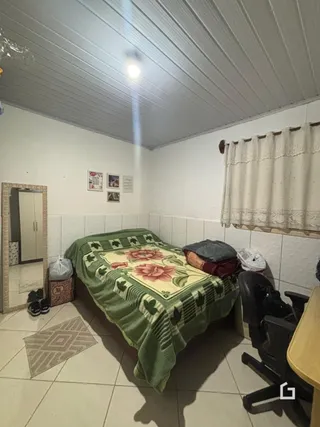 Foto de um quarto com cama e janela em uma residência.