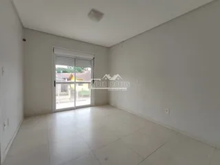 Ambiente interno de uma sala com piso claro e porta de vidro.