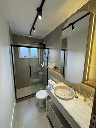 Foto de um banheiro moderno com box de vidro e bancada de mármore.