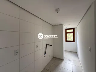 Corredor interno com paredes brancas e piso de cerâmica em uma residência.