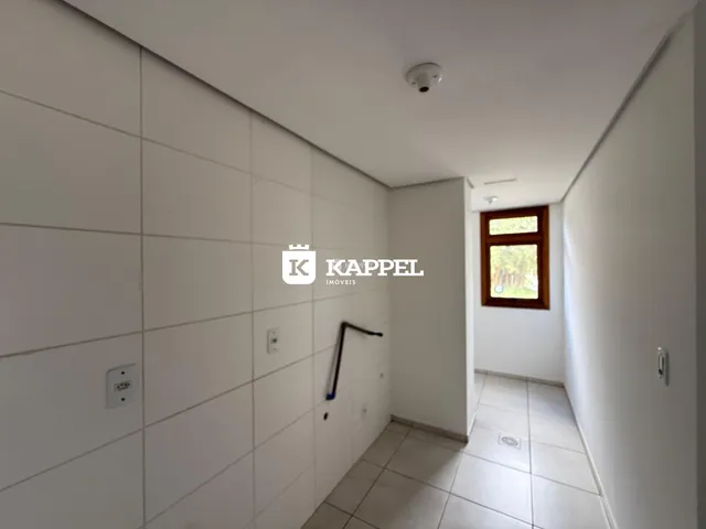 Corredor interno com paredes brancas e piso de cerâmica em uma residência.