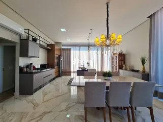 Sala de estar com piso de mármore e luminária de cristal.