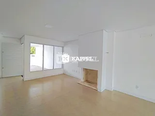 Uma sala ampla com portas de vidro que dão acesso a uma área externa.