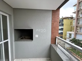 Vista da fachada de um apartamento em Lajeado, Brasil, mostrando uma parede e uma coluna de tijolo.