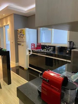 Interior da cozinha com armários escuros e piso de madeira clara.