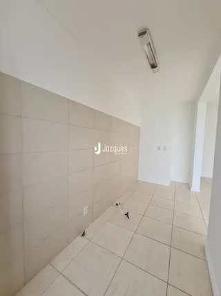 Corredor interno com piso de cerâmica e paredes brancas.