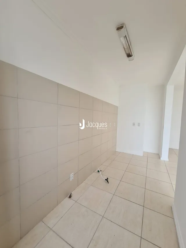 Corredor interno com piso de cerâmica e paredes brancas.